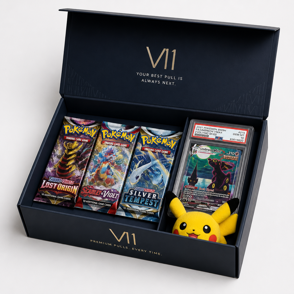 Open Vault 11 subscription box showing three Pokémon booster packs, a graded card slab, and a small Pikachu plushie
